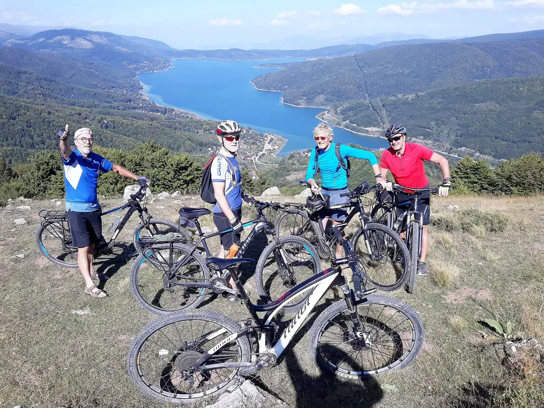Mountain bikers above a long blue lake